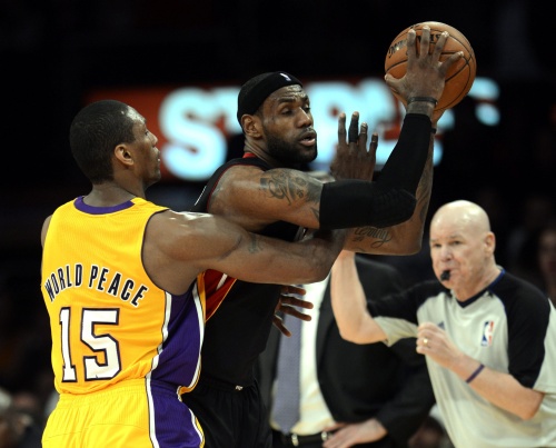 LeBron James (M) van Miami Heat in duel met Metta World Peace (L) van Los Angeles Lakers. EPA