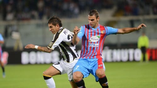Panagiotis Tachtsidis (R) van Catania in duel met Roberto Pereyra (L) van Udinese. EPA
