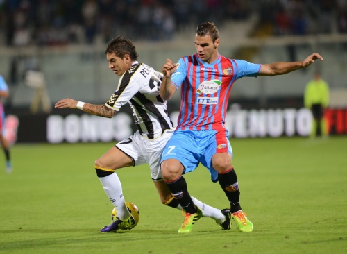 Panagiotis Tachtsidis (R) van Catania in duel met Roberto Pereyra (L) van Udinese. EPA