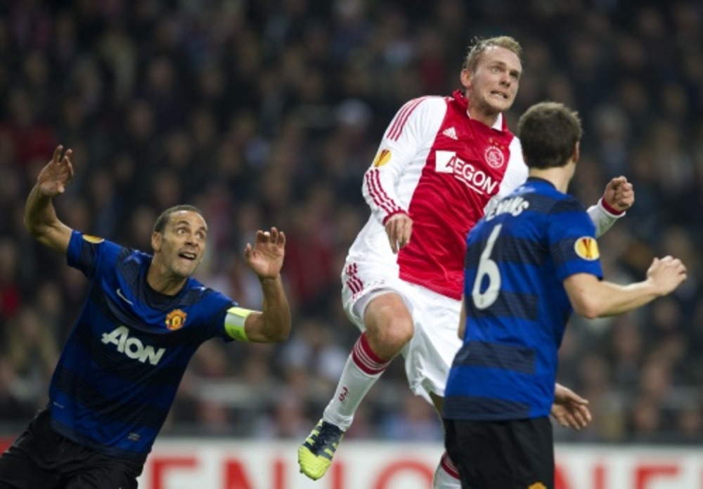 Siem de Jong van Ajax wacht met Rio Ferdinand van Manchester United op de bal. ANP