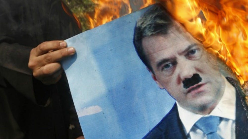 Demonstrant in Syrie steekt een foto Medvedev in brand