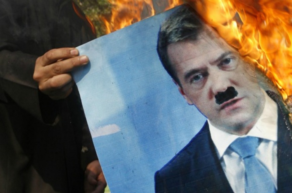 Demonstrant in Syrie steekt een foto Medvedev in brand