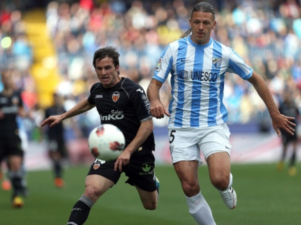 Pablo Piatti (L) van Valencia in duel om de bal met Martin Demichelis. EPA