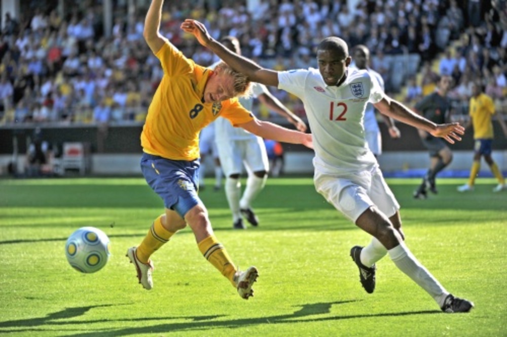 Fabrice Muamba (R) voor Engeland in duel met Andreas Landgren het Zweeds elftal. EPA