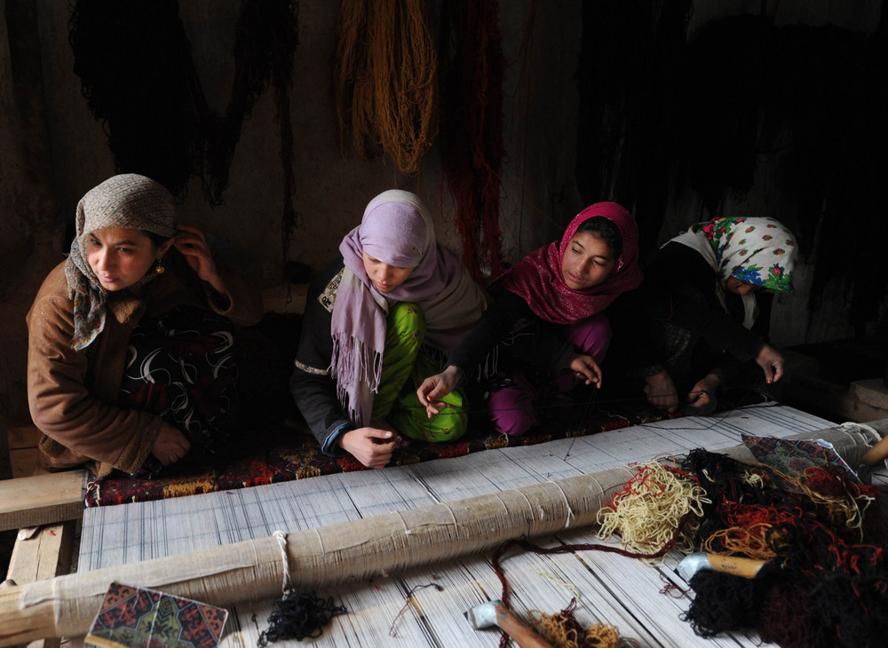 Een Afghaanse vrouwen weven een kleed