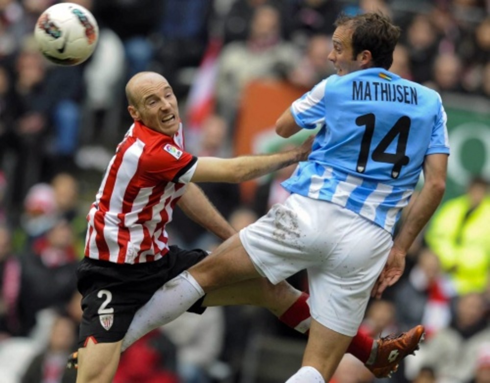 Gaizka Toquero (L) van Athletic Bilbao in duel met Joris Mathijsen van Malaga. EPA
