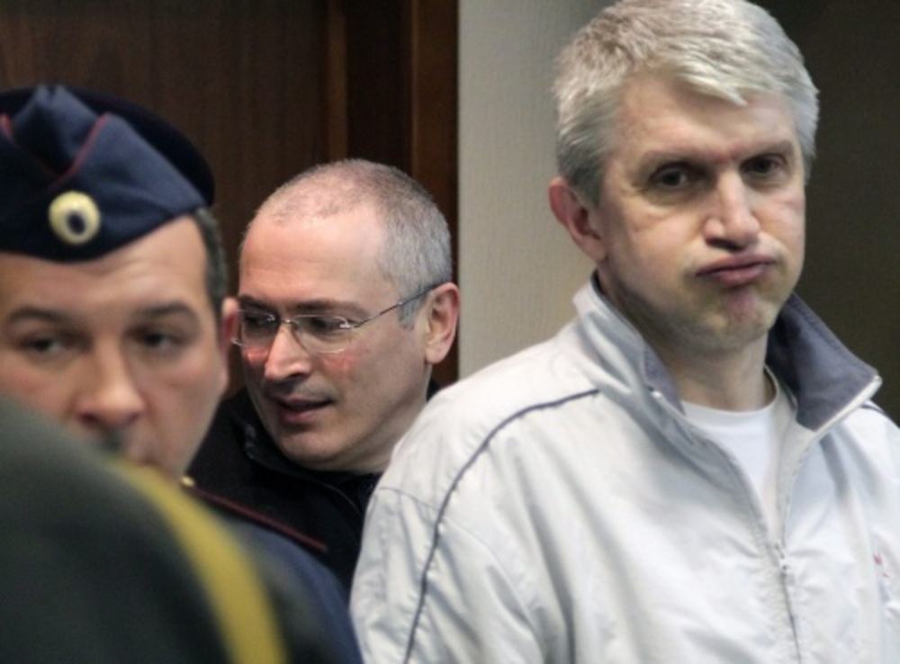 Platon Lebedev (R) met op de achtergrond Michail Chodorkovski. EPA
