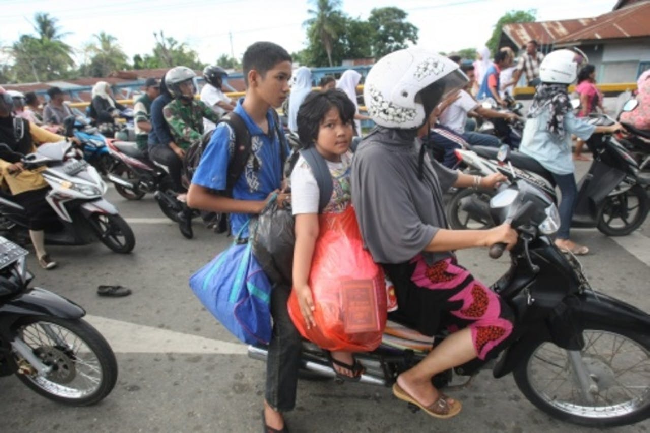 Inwoners vluchten naar hoger gelegen gebieden na een tsunamiwaarschuwing. EPA