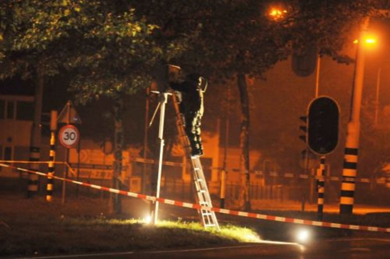 Een medewerker van de EOD onderzoekt zondag een explosief aan een flitspaal (archieffoto 23 oktober). ANP