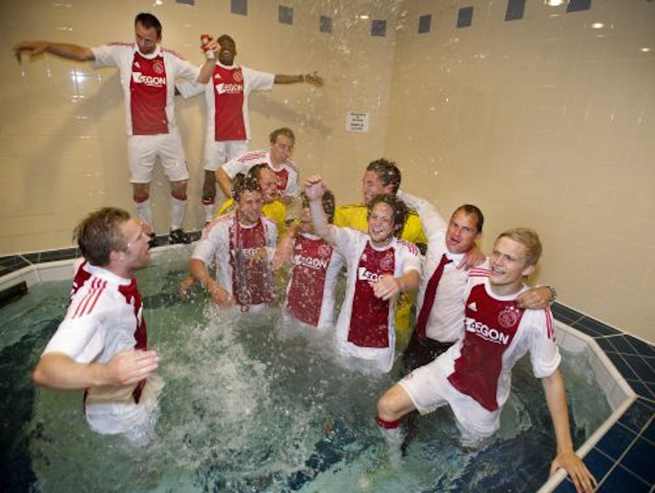 Trainer Frank de Boer van Ajax (2e van rechts) viert het behalen van de landstitel met zijn spelers in de kleedkamer. ANP