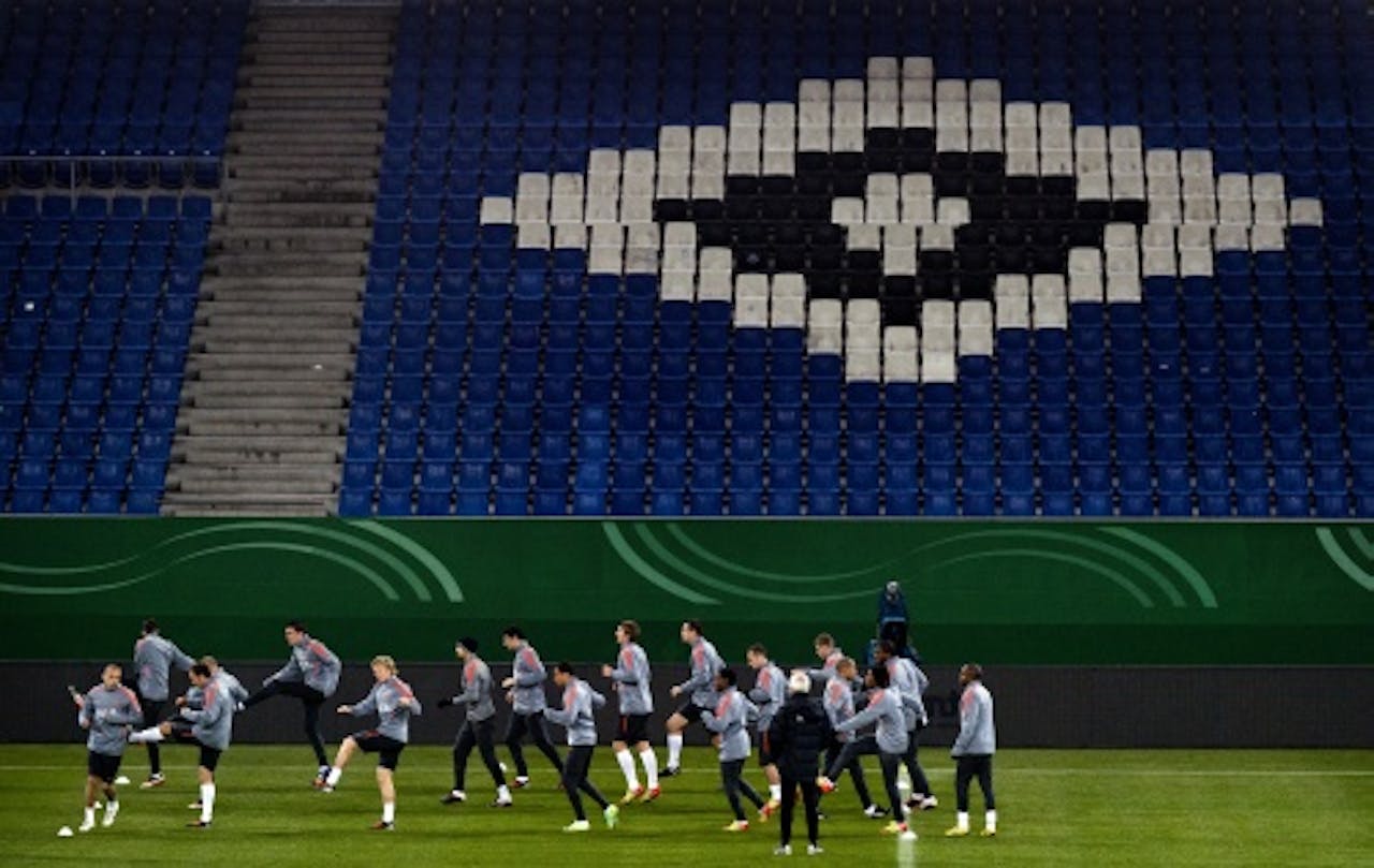 De selectie van het Nederlands elftal loopt maandag warm tijdens de training in de Imtech Arena in Hamburg. ANP
