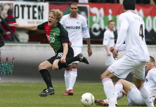 Bjorn Vleminckx (L) van NEC wordt onderuit gehaald in de wedstrijd tegen PSV. ANP 