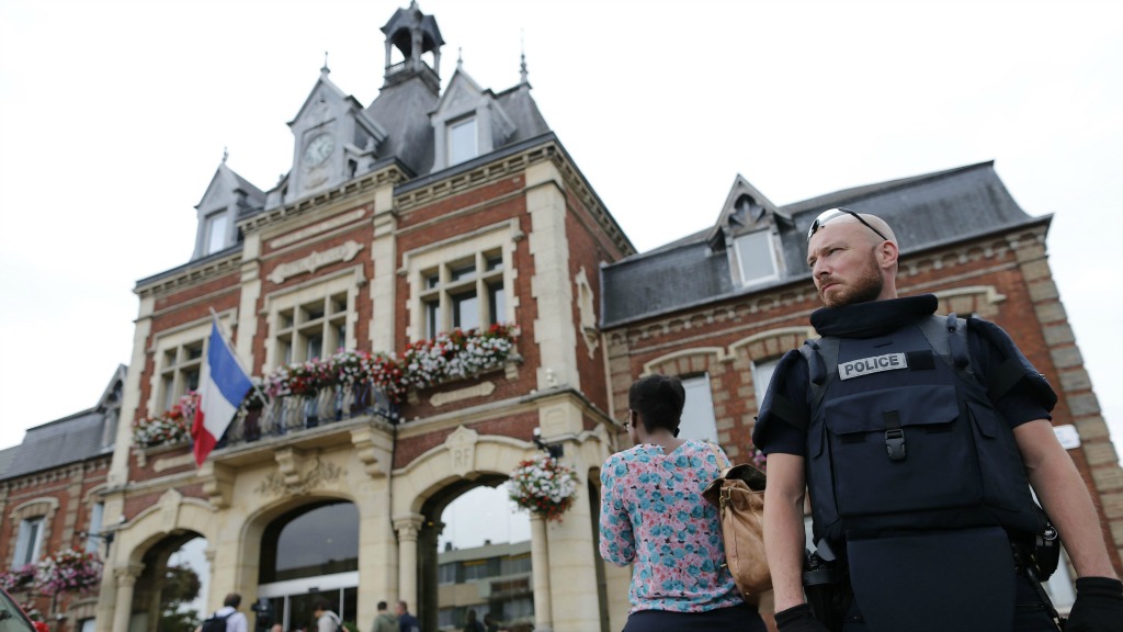 Een politieagent houdt wacht bij de kerk in Saint-Etiènne-du-Rouvray. Foto ANP