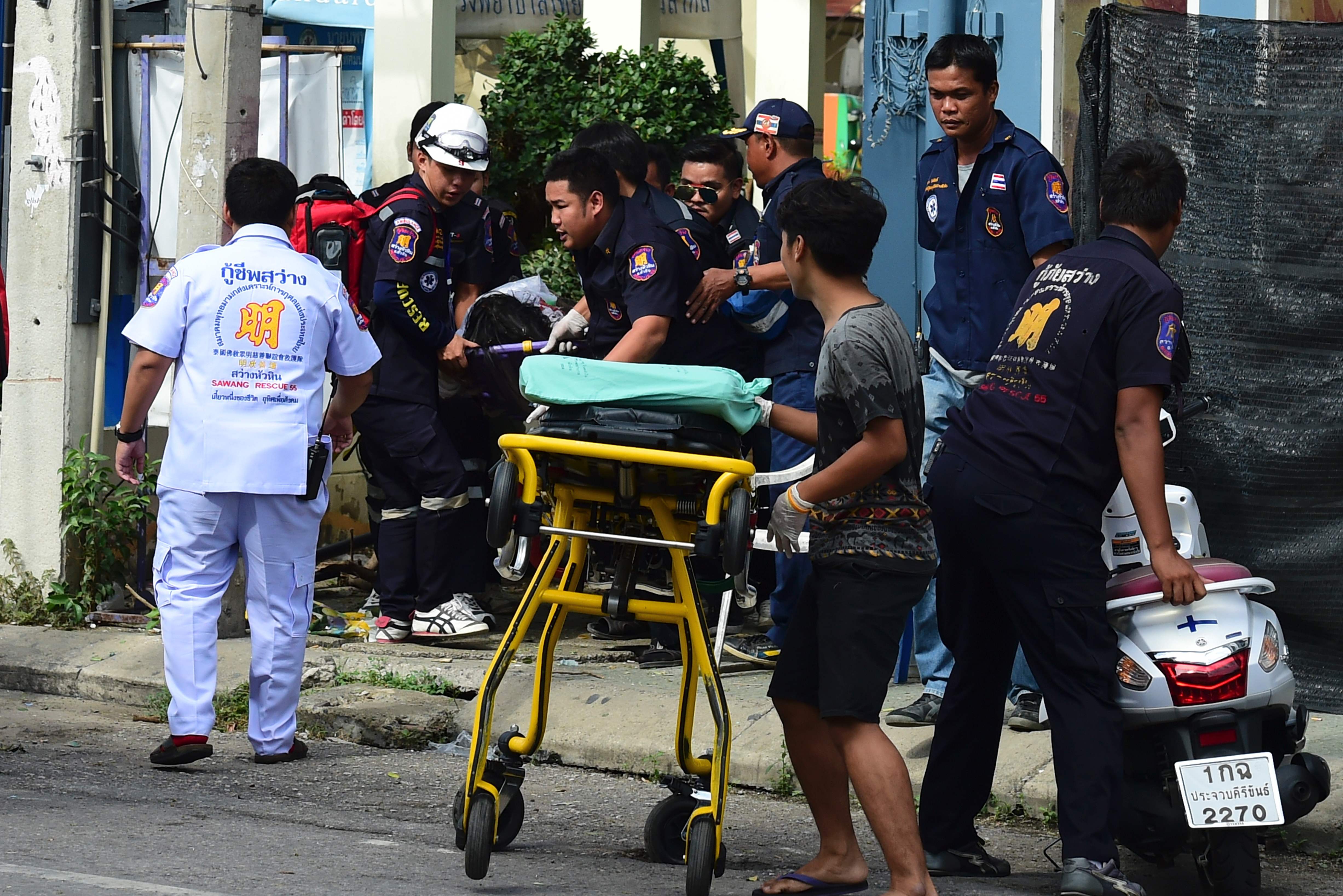 Thaise hulpdiensten helpen een gewonden na een van de aanslagen in Hua Hin in Thailand. Foto AFP