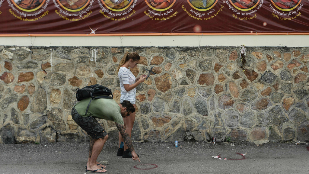 Toeristen nemen een kijkje bij de plaats van een bomaanslag in Hua Hin.