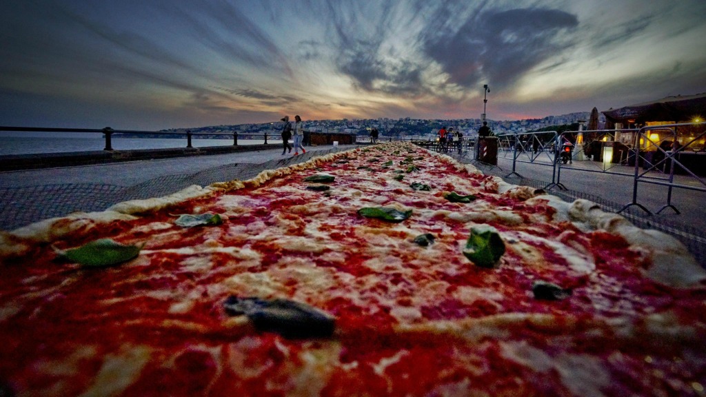 Deze pizza langs de kust van Napels probeerde met 2 kilometer lengte het wereldrecord langste pizza ooit te verbreken. Foto ANP