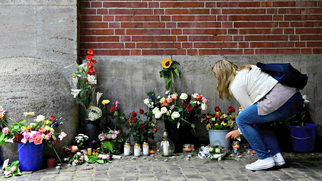 Een meisje legt bloemen bij een school ter nagedachtenis aan de aanslag in Nice. Foto ANP