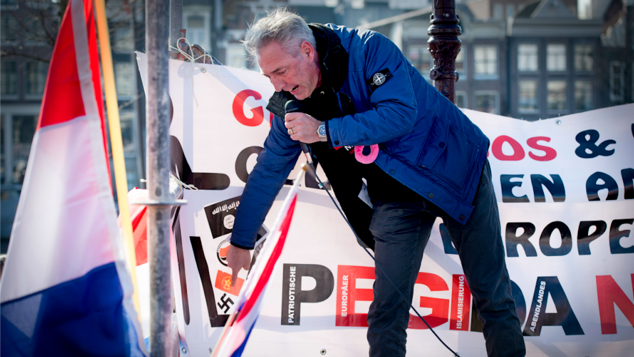 Voorman Edwin Wagensveld van de anti-islambeweging Pegida wijst tijdens een toespraak naar een hakenkruis. Wagensveld werd gearresteerd. De gemeente Amsterdam had van tevoren gezegd dat nazisymbolen verboden zijn. (Foto: ANP)