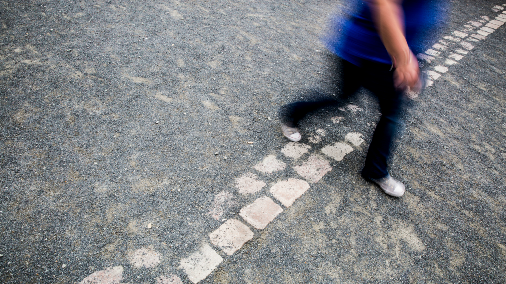 Een vrouw stapt over de plek waar ooit de Berlijnse muur stond (Foto: Rob Voss/HH)