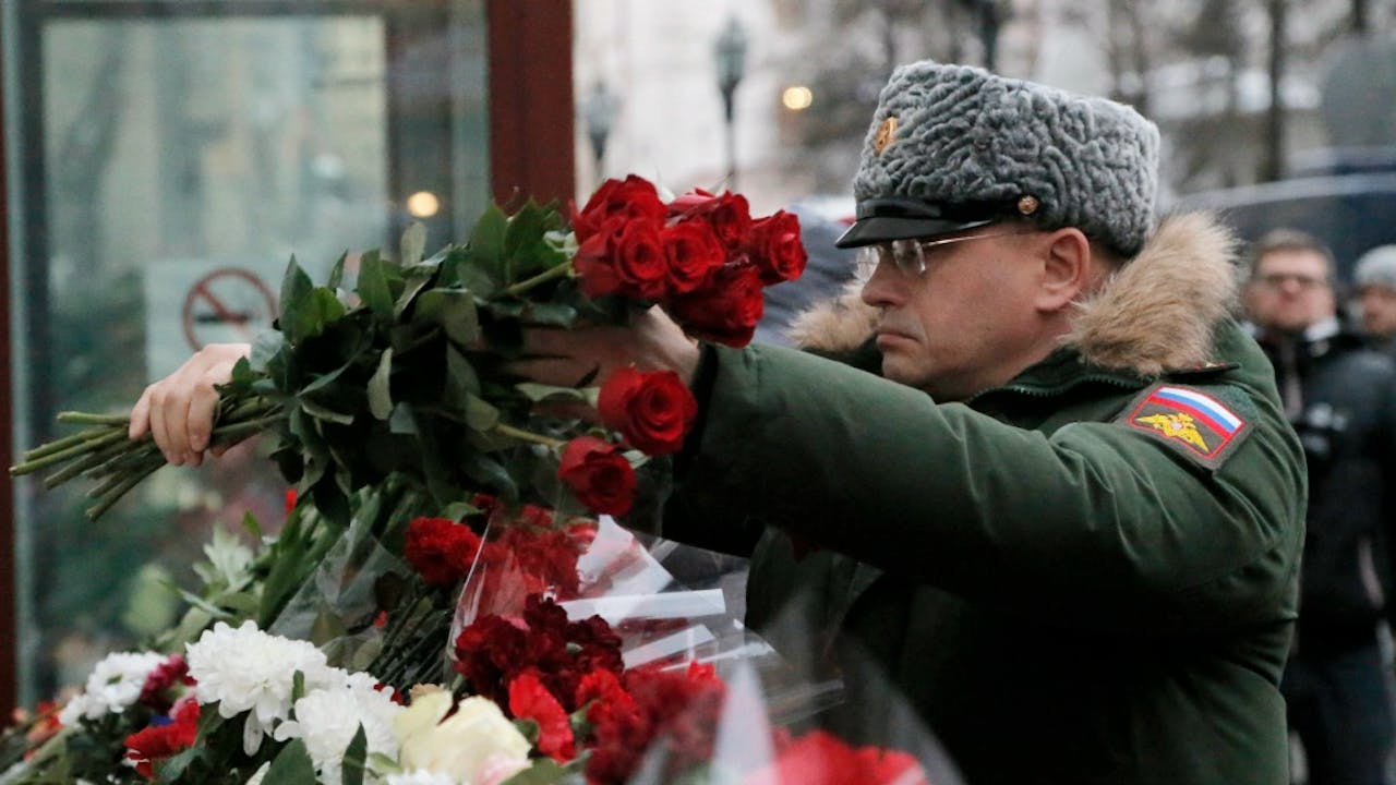 Een Russische soldaat legt bloemen bij een herdenkingsplek voor de omgekomen koorleden van het Alexandrov Ensemble. Foto ANP