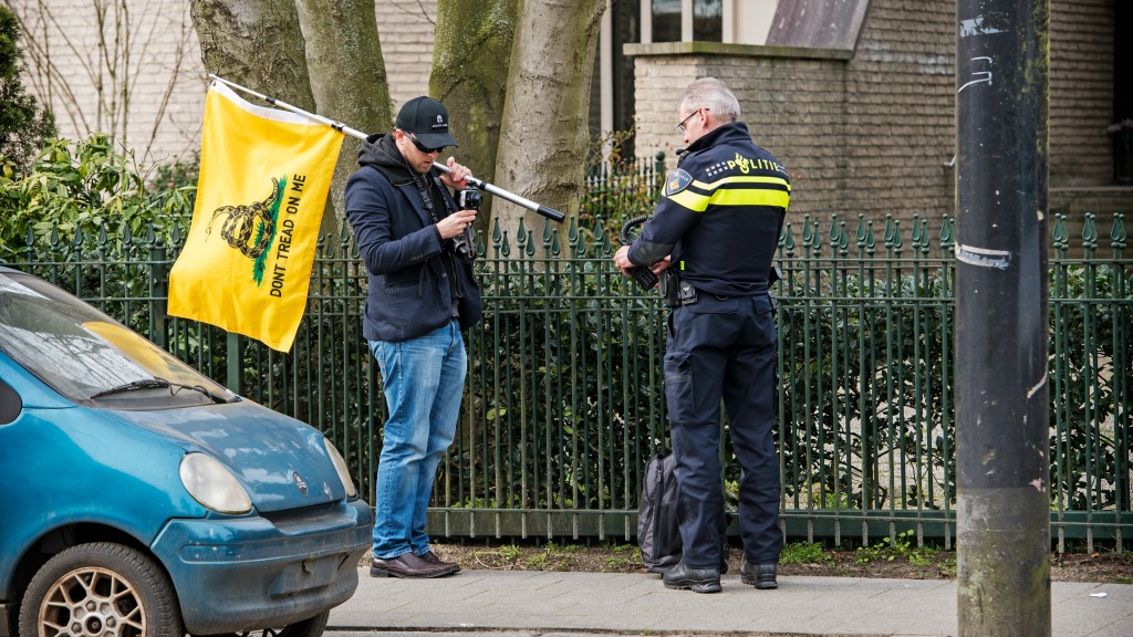 Bij de ambtswoning van de Turkse consul in de wijk Hillegersberg demonstreert een man met een vlag. De Turkse minister Mevlut Cavusoglu was van plan om genodigden toe te spreken in de ambtswoning.
Foto: ANP/Marten van Dijl