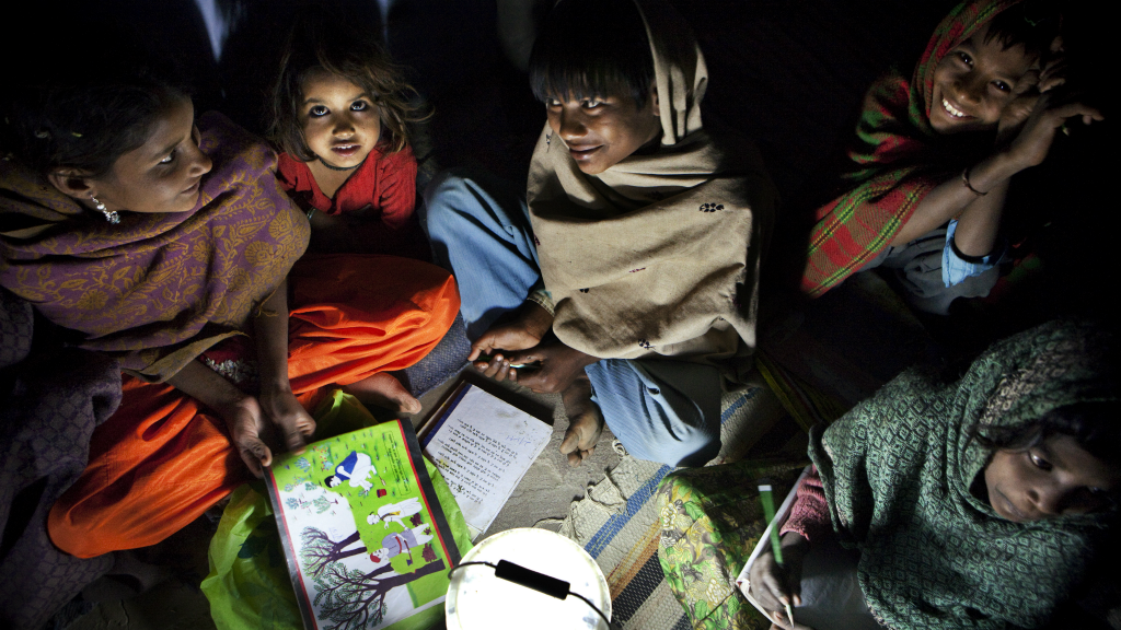 In India is nog altijd 40% van de bevolking analfabeet. Op de foto, kinderen die overdag werken en 's avonds les krijgen sinds er lampjes met zonnepanelen bestaan. (Foto: Dieter Telemans/Hollandse Hoogte, 2010)