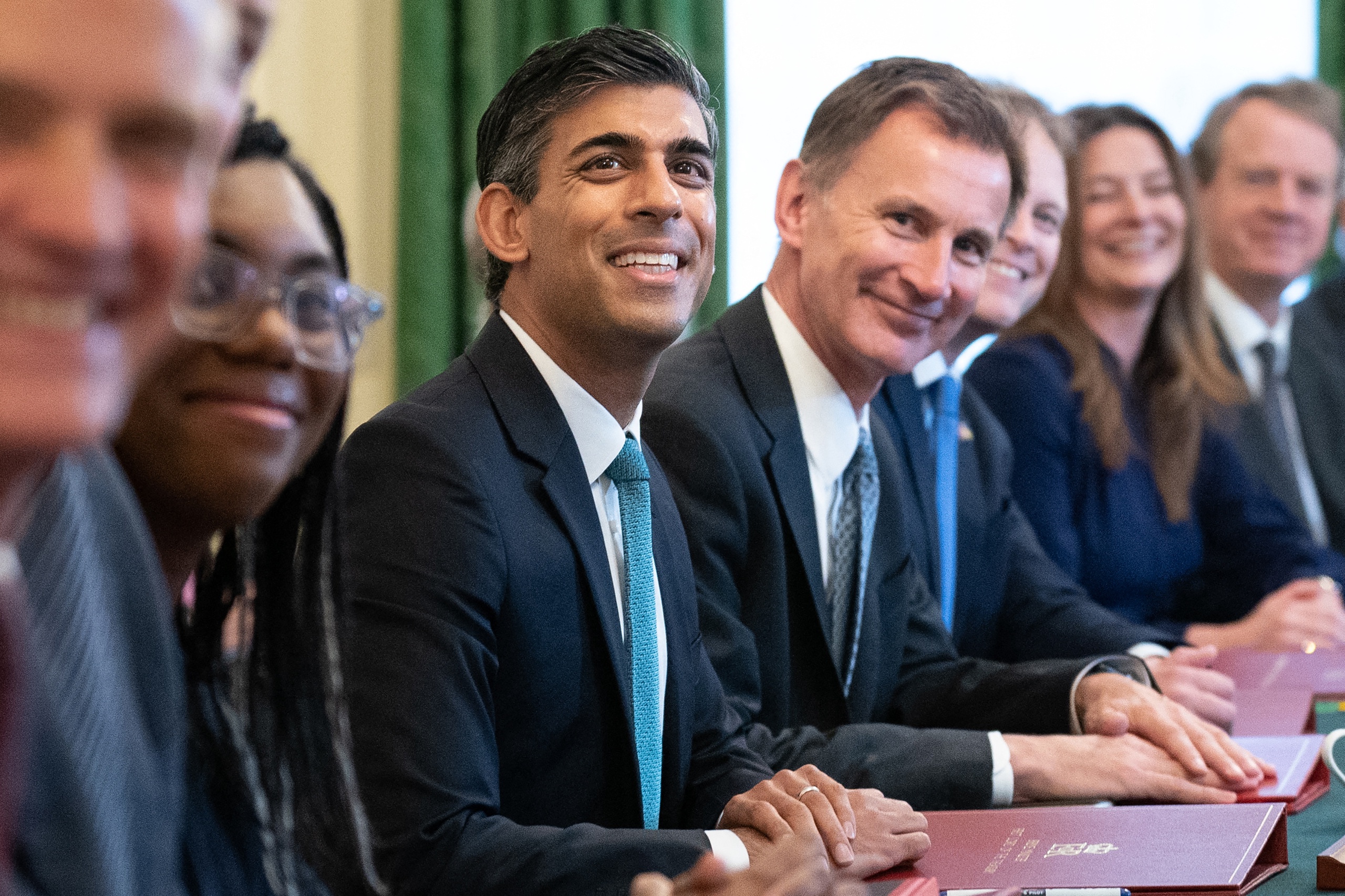 Britain's Prime Minister Rishi Sunak (C) poses for a photograph alongside Britain's Chancellor of the Exchequer Jeremy Hunt (centre right) and Britain's Secretary of State for International Trade, President of the Board of Trade and Minister for Women and Equalities Kemi Badenoch (centre left) at the first cabinet meeting under the new Prime Minister, Rishi Sunak in 10 Downing Street in central London on October 26, 2022. Sunak's largely same-look cabinet holds an inaugural meeting today before he heads to the House of Commons for his first weekly "Prime Minister's Questions", when he will battle Labour leader Keir Starmer and other opposition lawmakers. Stefan Rousseau / POOL / AFP