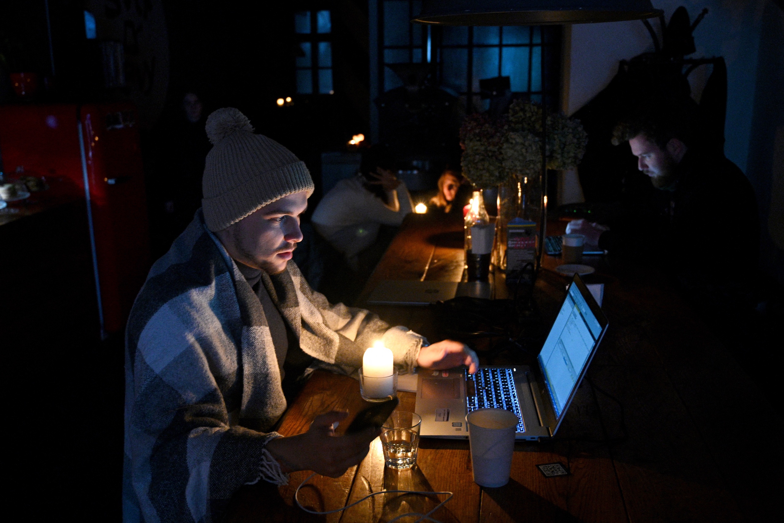 Mensen rusten uit in een coffeeshop in Lviv terwijl de stad een geplande stroomuitval doormaak.