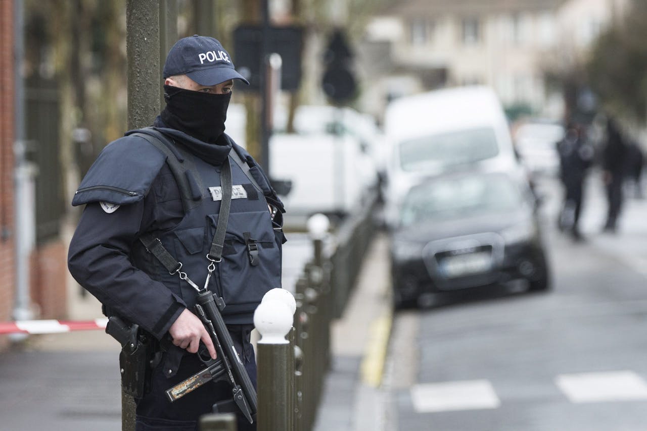 Een Franse politieagent staat op straat bij het appartement waar de wapens werden gevonden in 2016