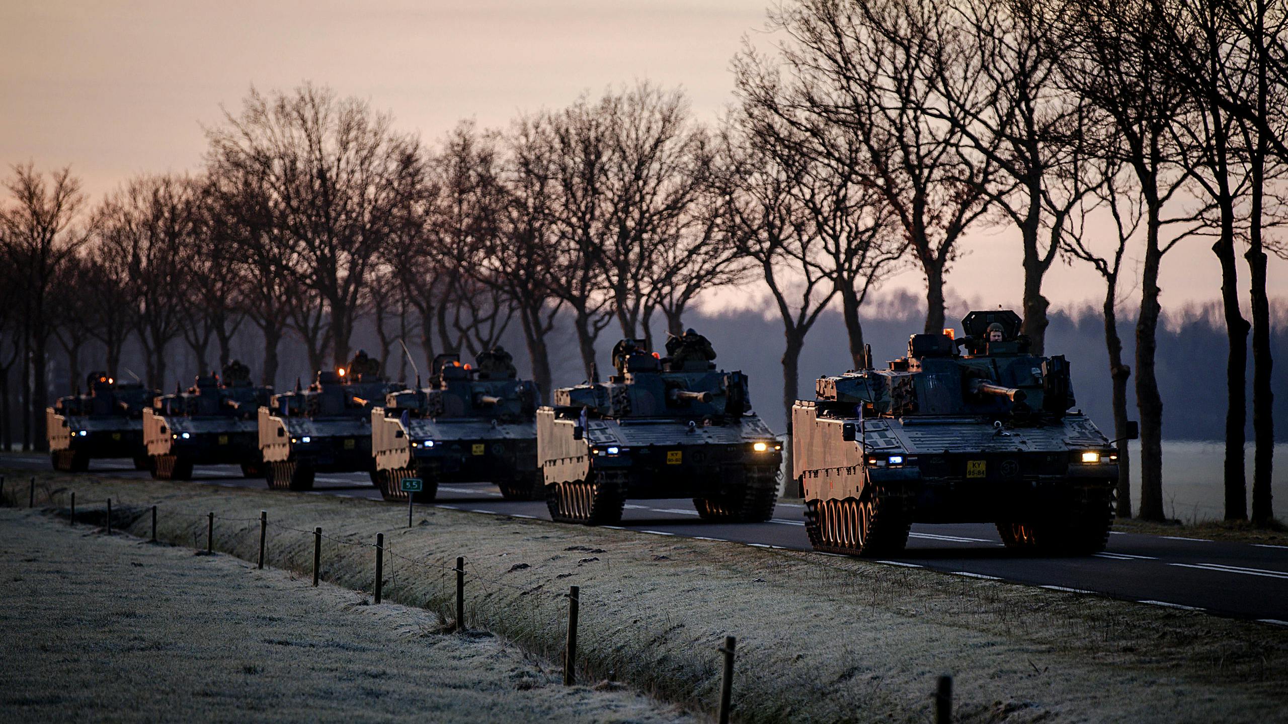 Een cologne landmacht voertuigen rijden richting het station van Steenwijk om per trein vervoerd te worden naar Duitsland voor de NAVO flitsmacht.