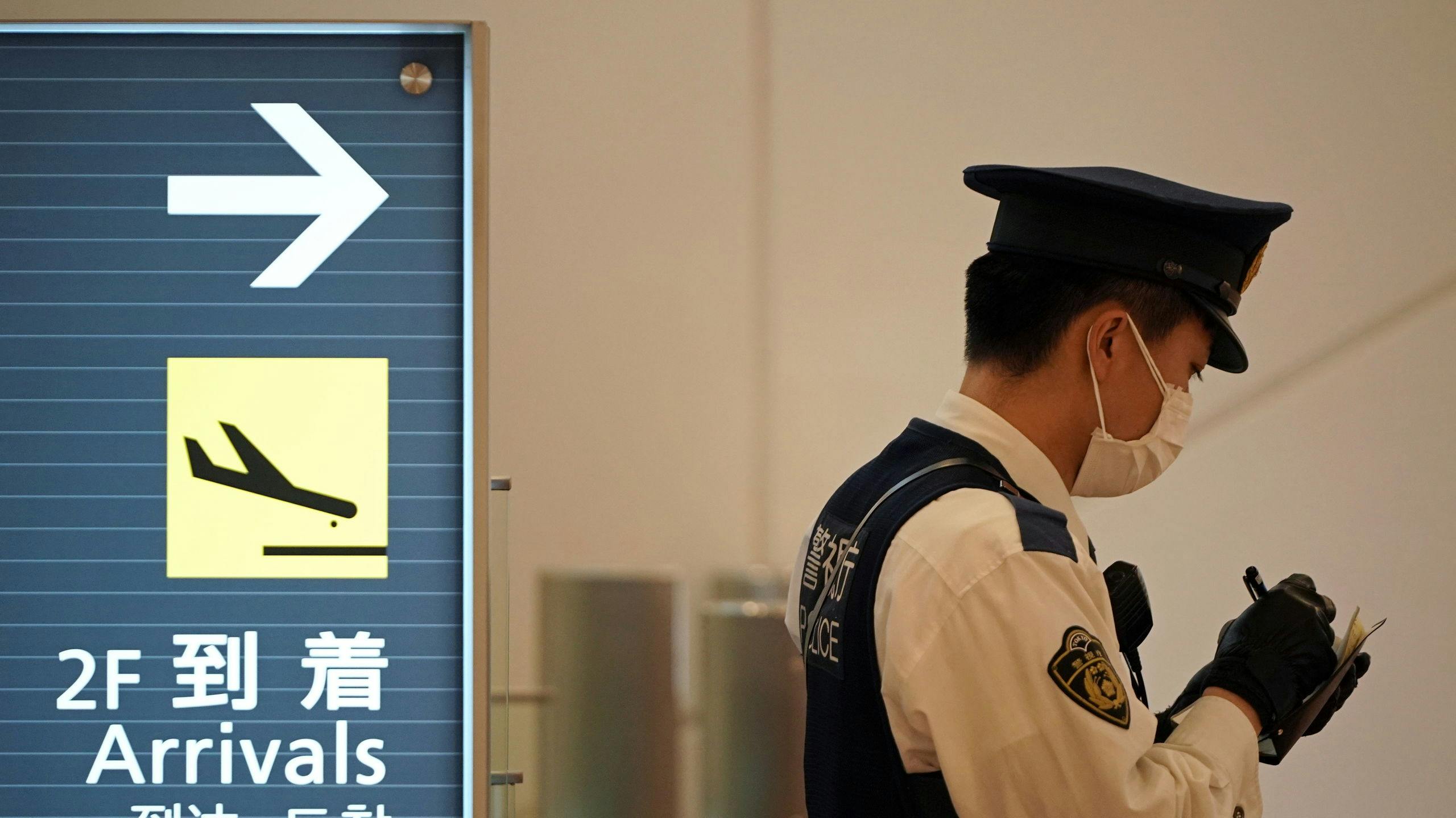 Agent met mondkapje op de internationale luchthaven van Tokio