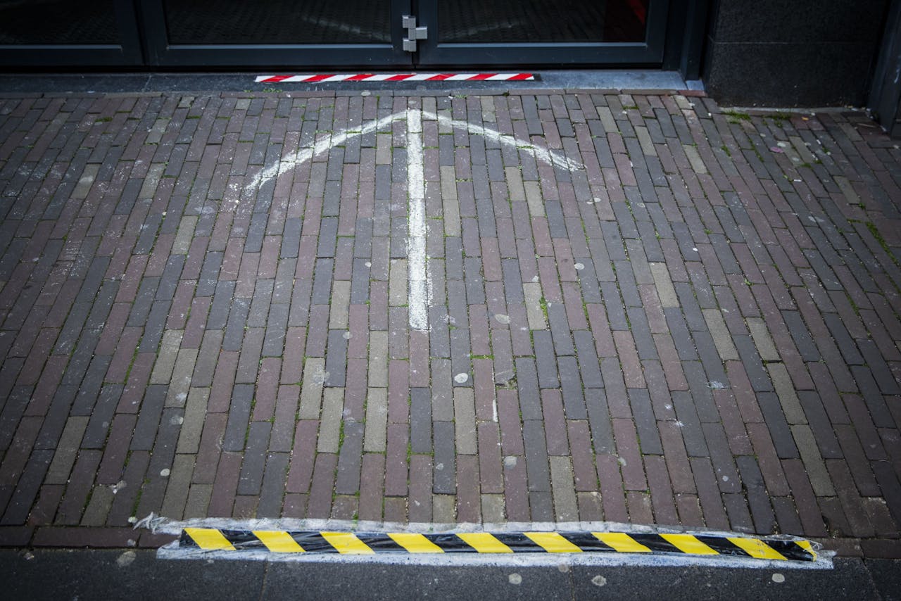 Strepen die aangeven dat klanten 1,5 meter afstand moeten bewaren in een winkelstraat in Haarlem.
