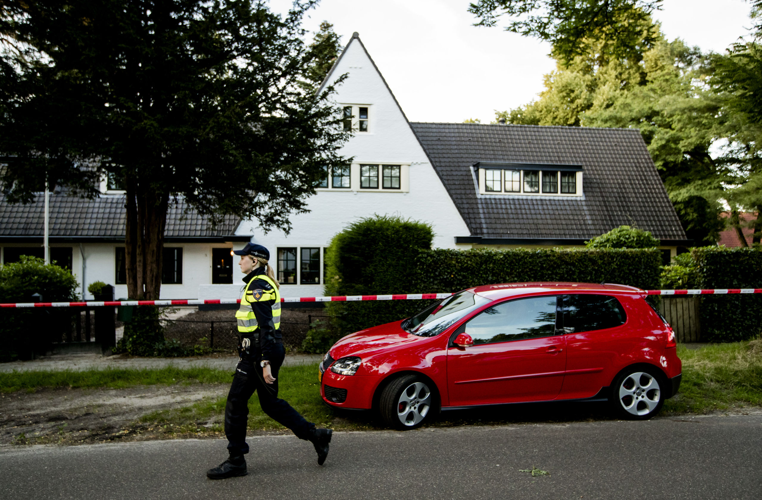 Een agent bij het huis van Koen Everink voorafgaand aan de reconstructie van de moord op de zakenman.