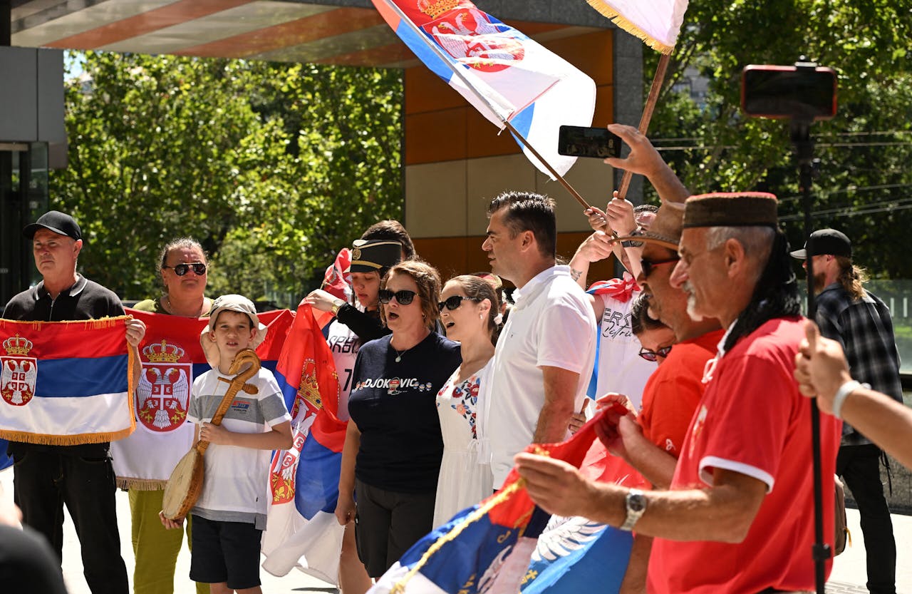 Supporters van Novak Djokovic met Servische vlaggen voor het gerechtsgebouw in Melbourne