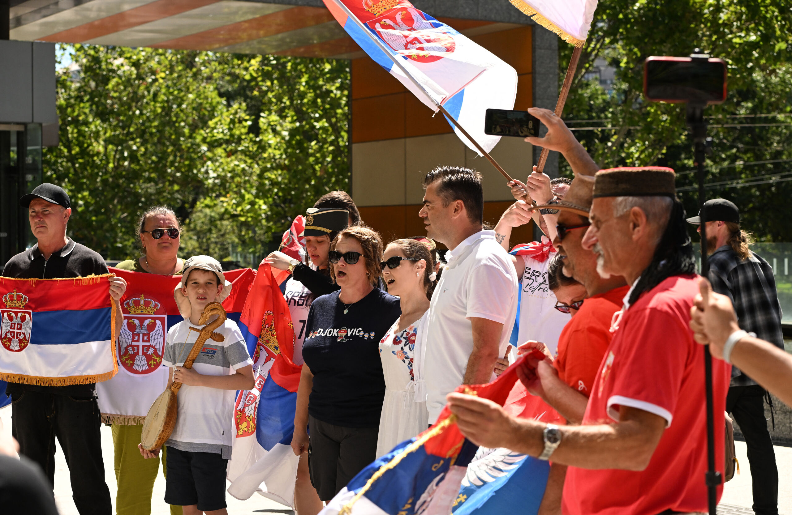 Supporters van Novak Djokovic met Servische vlaggen voor het gerechtsgebouw in Melbourne 