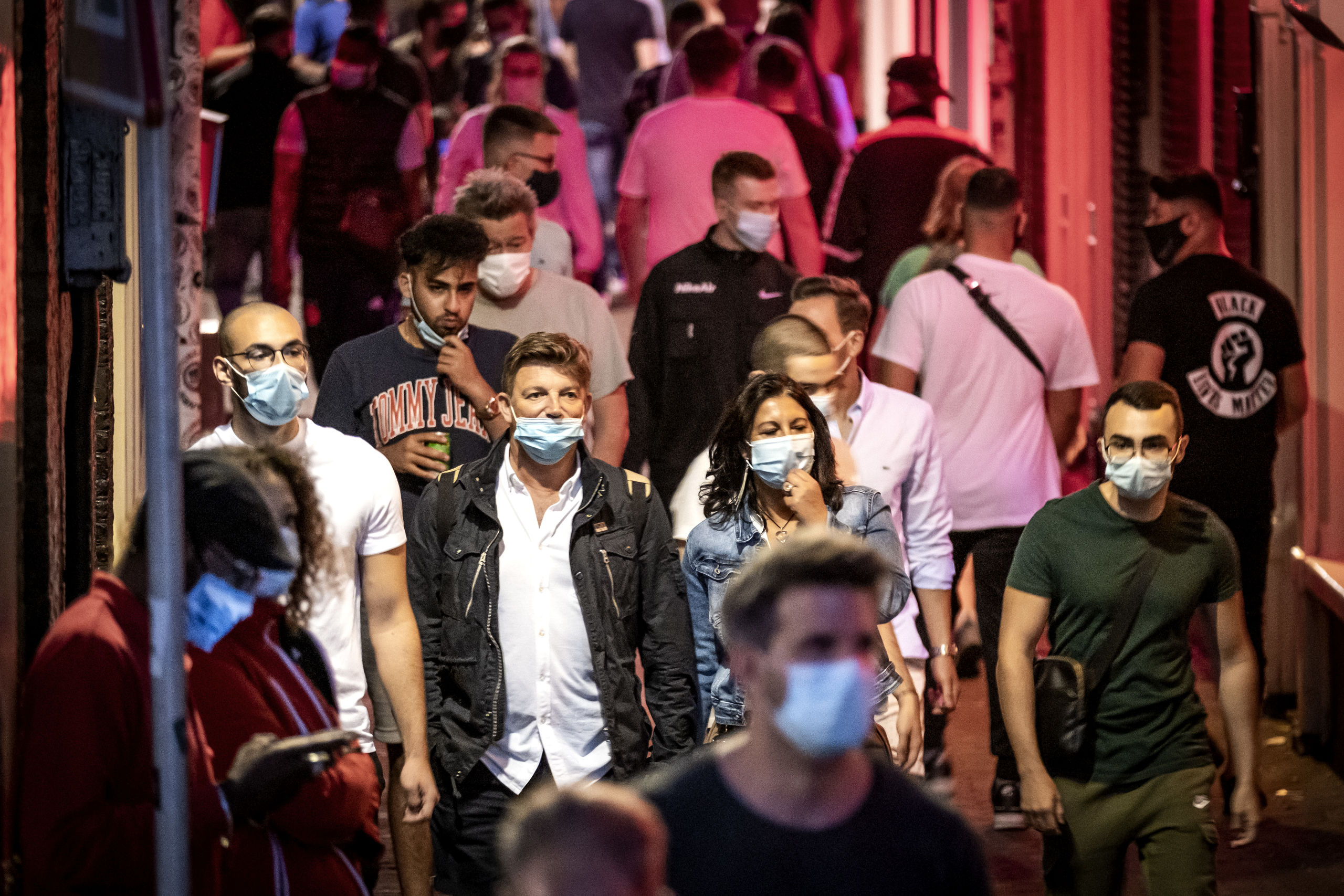 Toeristen met mondkapjes op de Wallen in Amsterdam