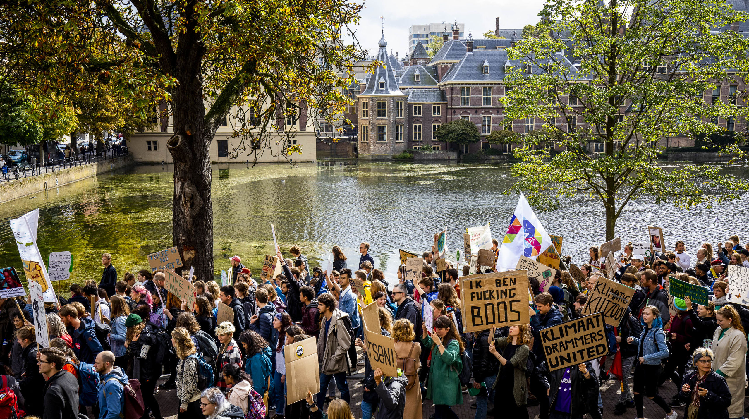 Deelnemers aan de klimaatmars lopen voorbij het Torentje en het Binnenhof. T