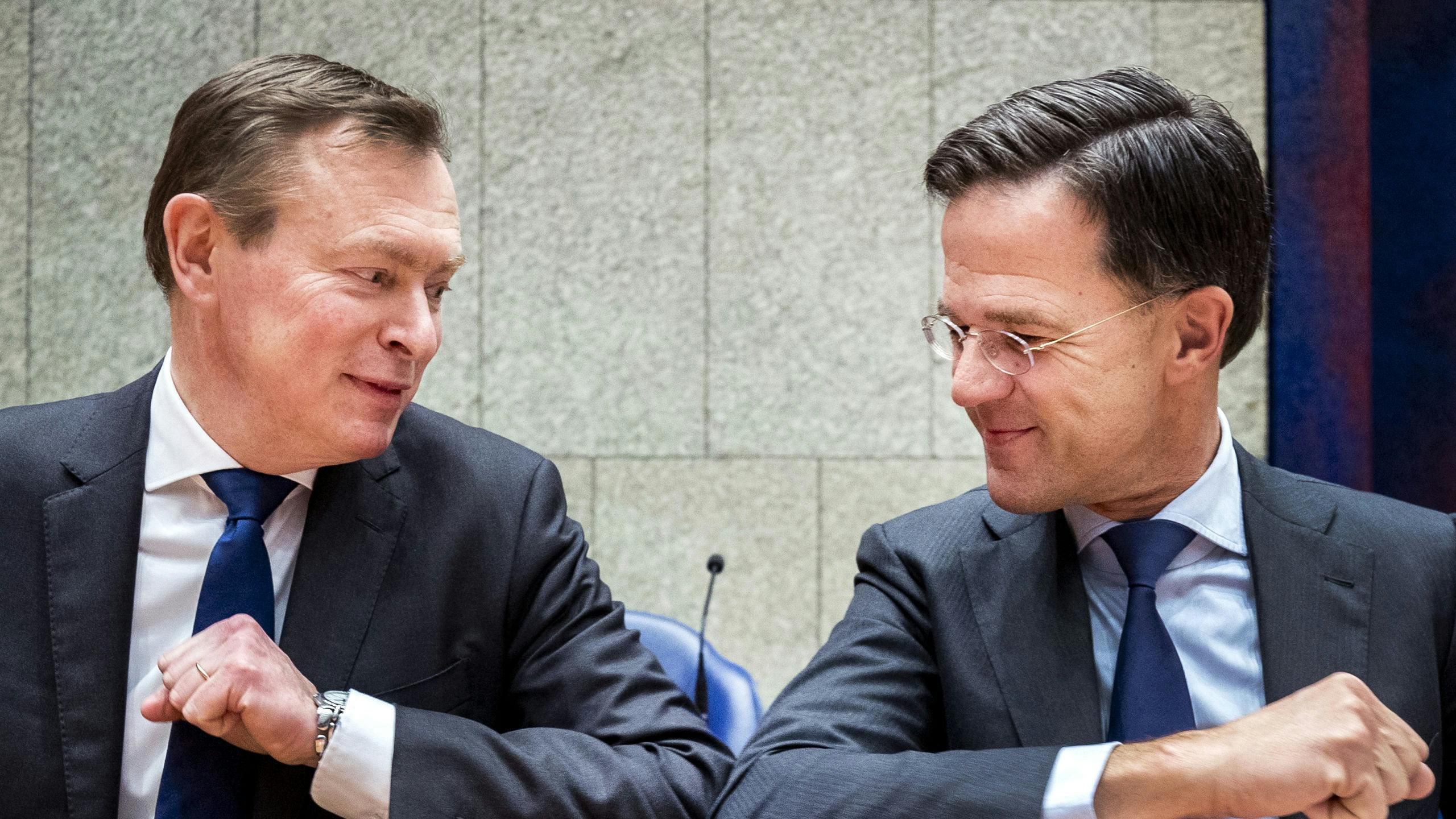 Premier Mark Rutte geeft minister Bruins voor Medische Zorg een ellebooggroet.