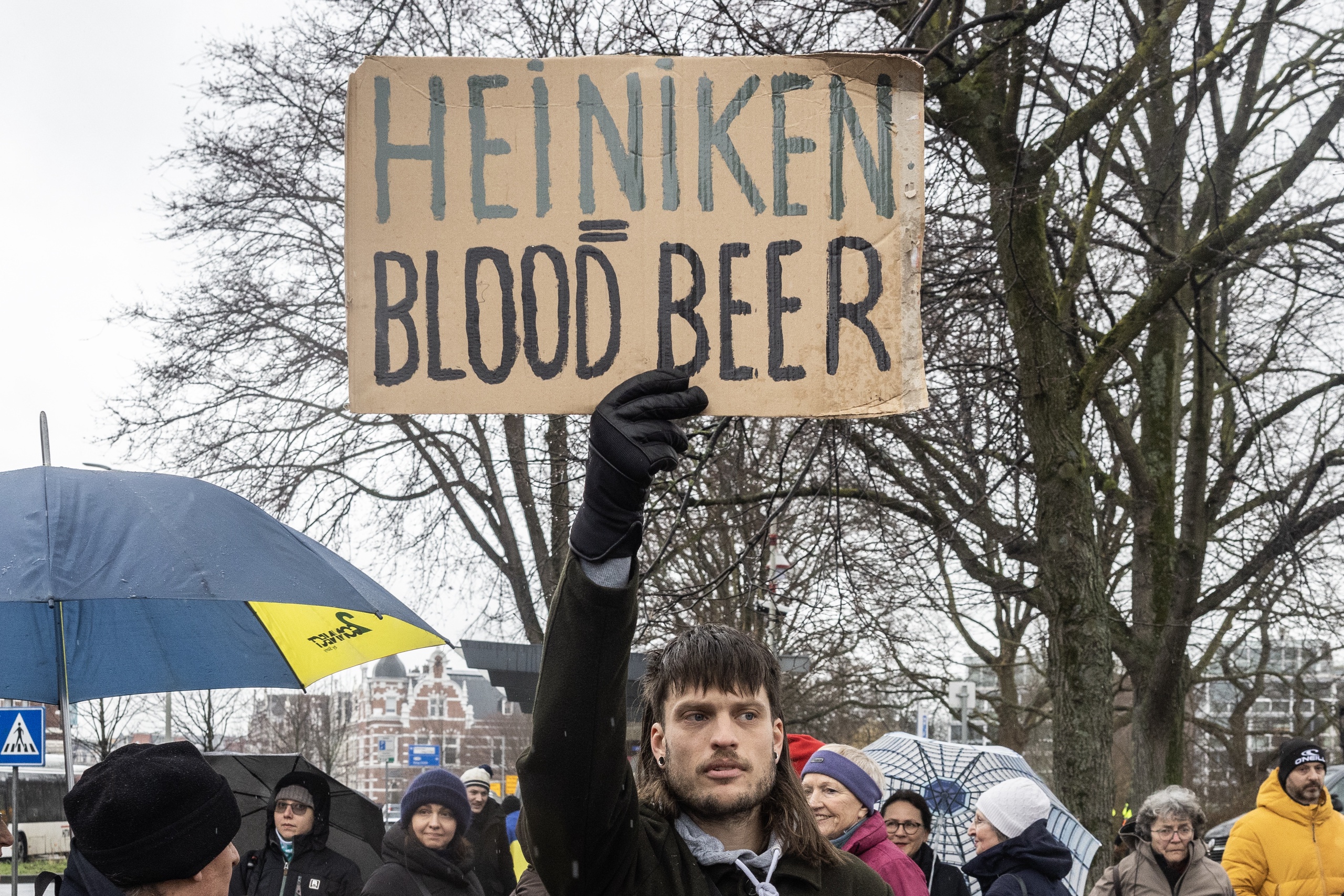 Protestbord tegen bierbrouwer Heiniken. Heineken investeert nog steeds in Rusland. Herdenkings- en solidariteitstocht voor Oekraïne in Den Haag. Het is precies een jaar geleden dat Rusland het buurland Oekraïne binnenviel. 