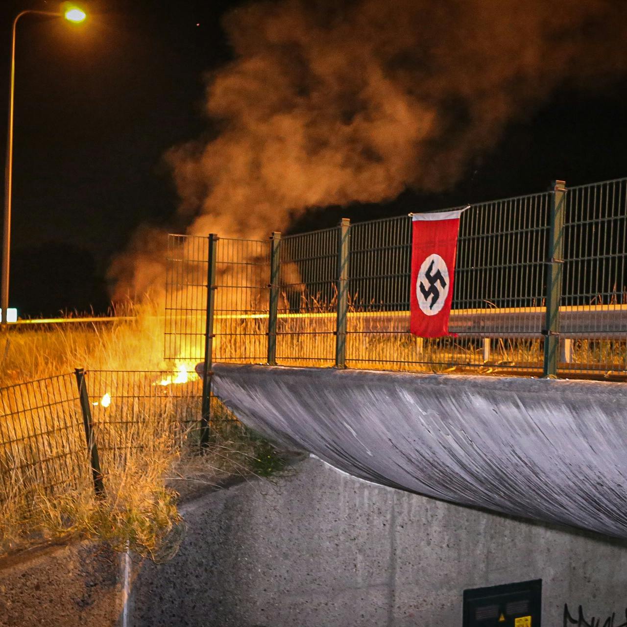 Hakenkruisvlag opgehangen aan een viaduct bij Stroe