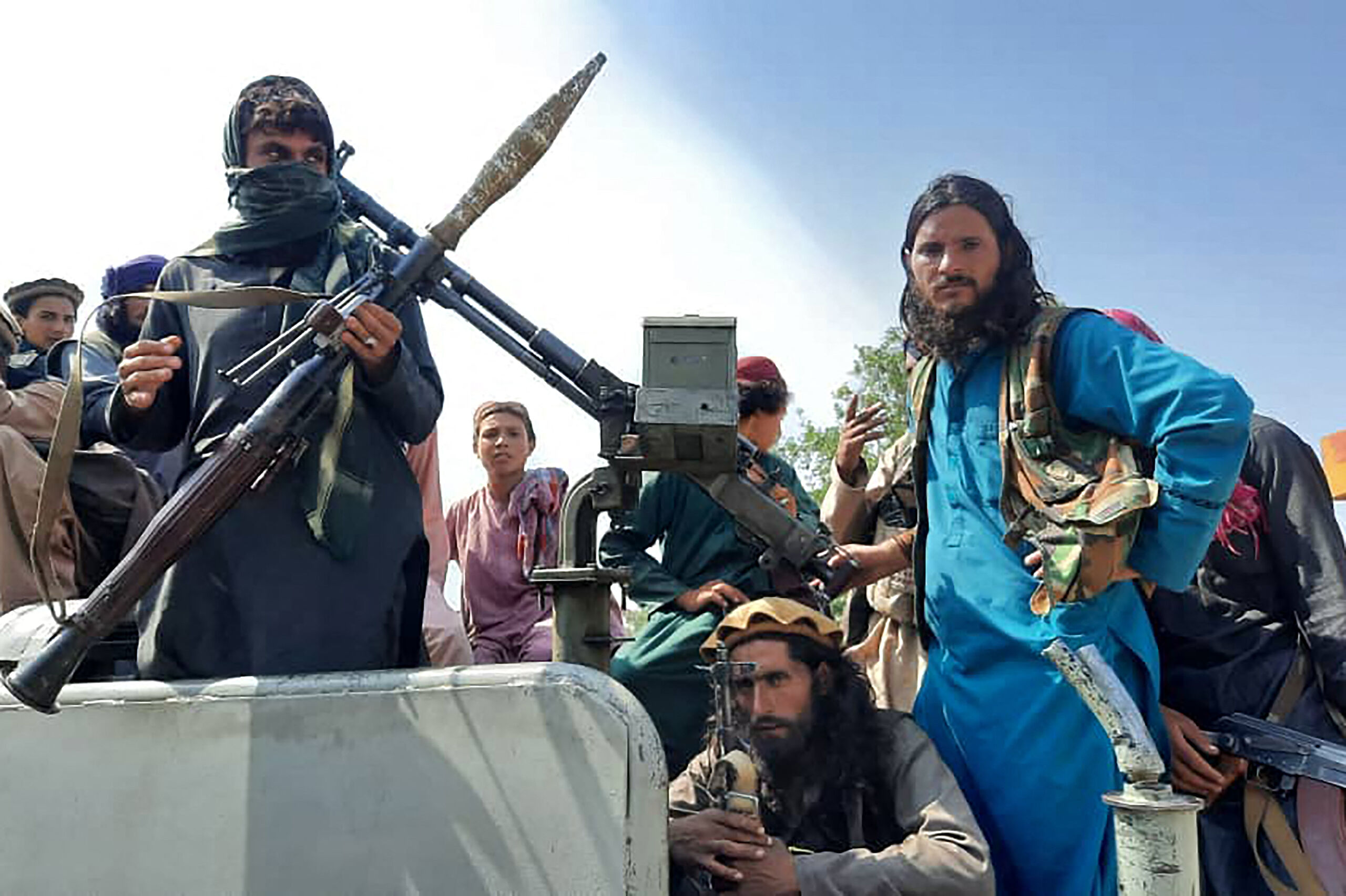 Taliban fighters sit over a vehicle on a street in Laghman province on August 15, 2021.  AFP