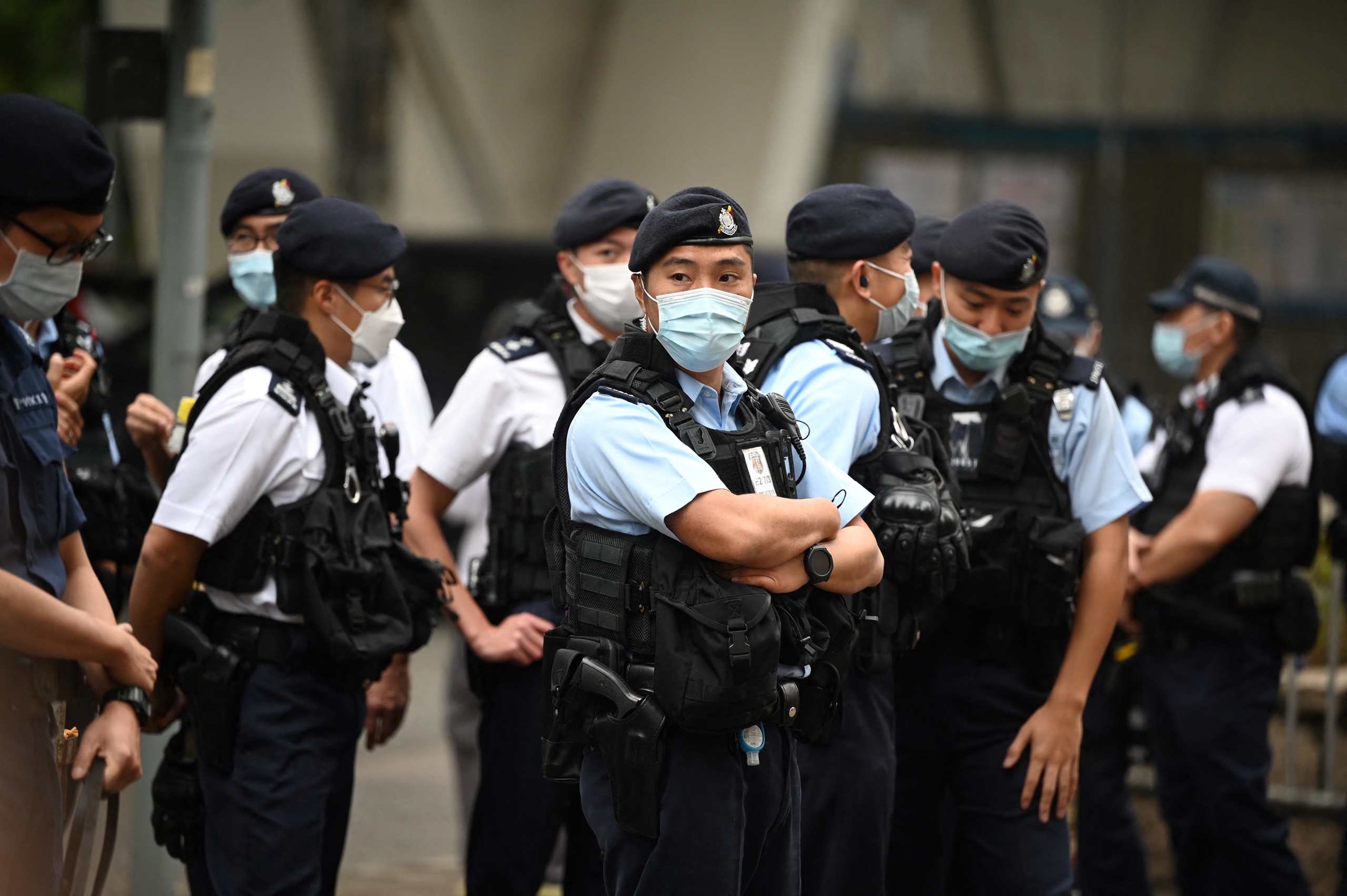 De politie van Hong Kong bewaakt het gerechtsgebouw. Het proces gaat om het houden van onofficiële voorverkiezingen in maart 2020, daarmee koos de prodemocratische beweging kandidaten voor de regionale parlementsverkiezingen. De verdachten zijn opgepakt in het kader van de omstreden veiligheidswet. 