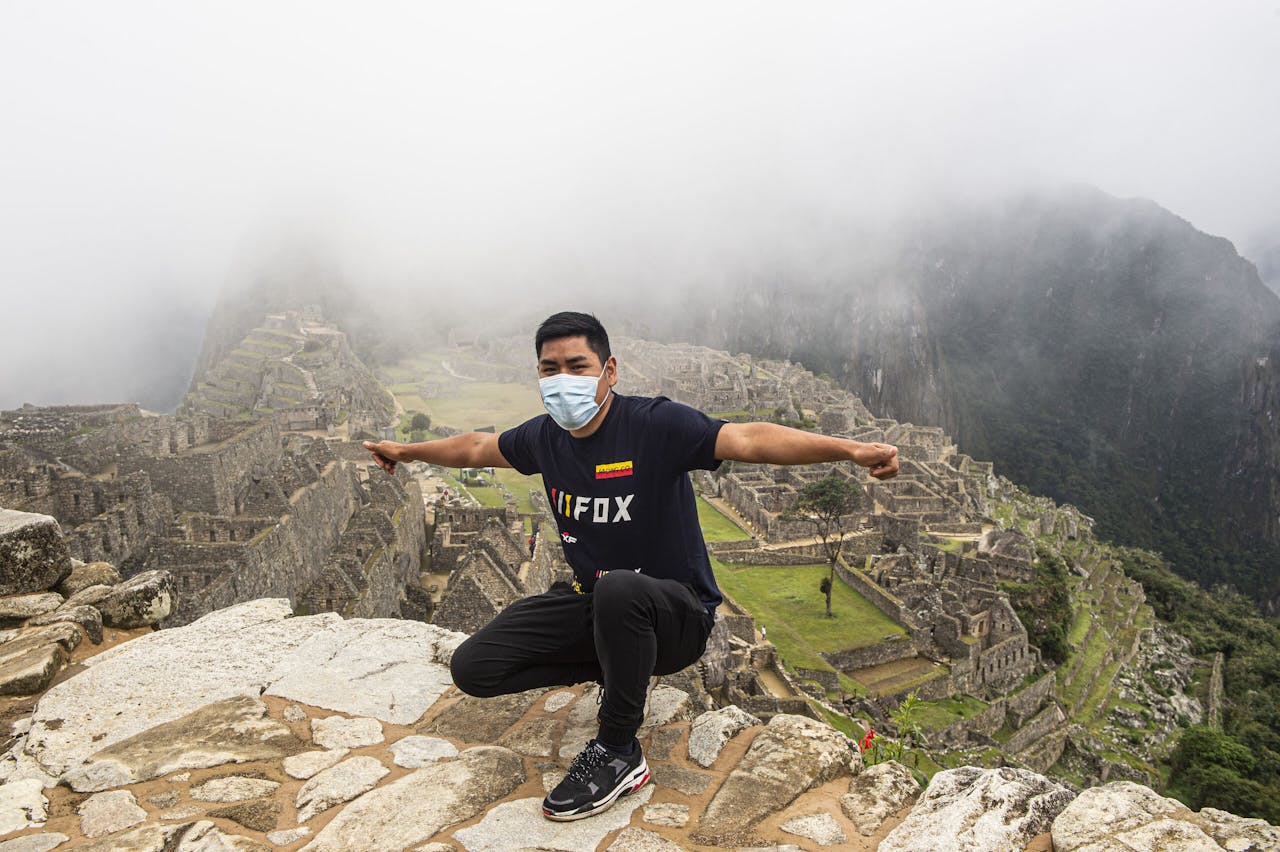 Een toerist poseert bij Machu Picchu. Dit Peruaanse wereldwonder ging van medio maart tot en met oktober op slot. Per dag zijn er nu 675 toeristen welkom; dat waren er voorheen ruim tweeduizend. ERNESTO BENAVIDES / AFP