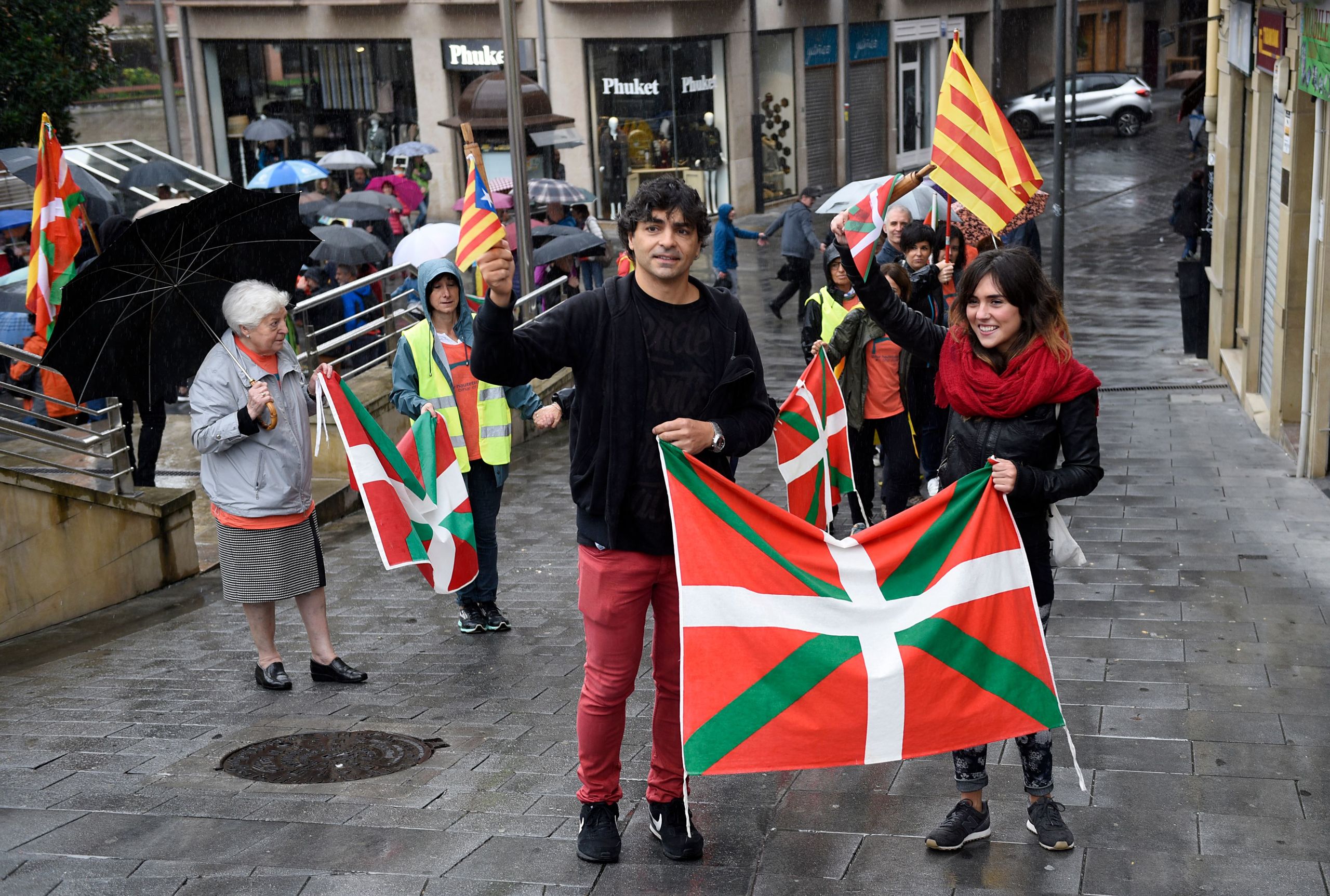 Mensen houden Catalaanse pro-onafhankelijkheidsvlaggen en vlaggen van Spaans Baskenland vast tijdens een demonstratie in de Noord-Spaanse stad Beasain, dat in Baskenland ligt.