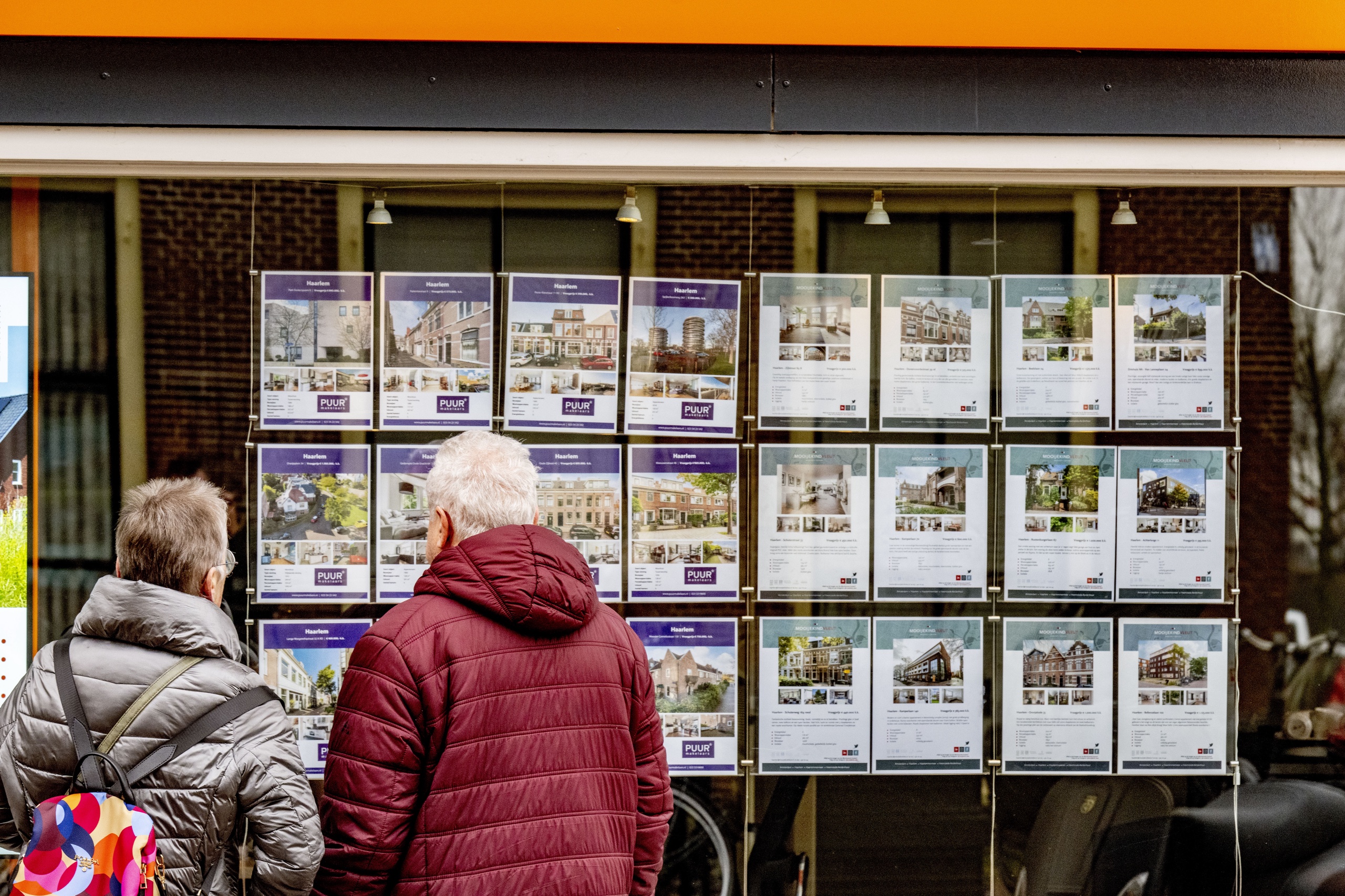 HAARLEM - Mensen kijken naar koopwoningen bij een makelaar hypotheekshop ANP/Hollandse Hoogte/ Robin Utrecht
