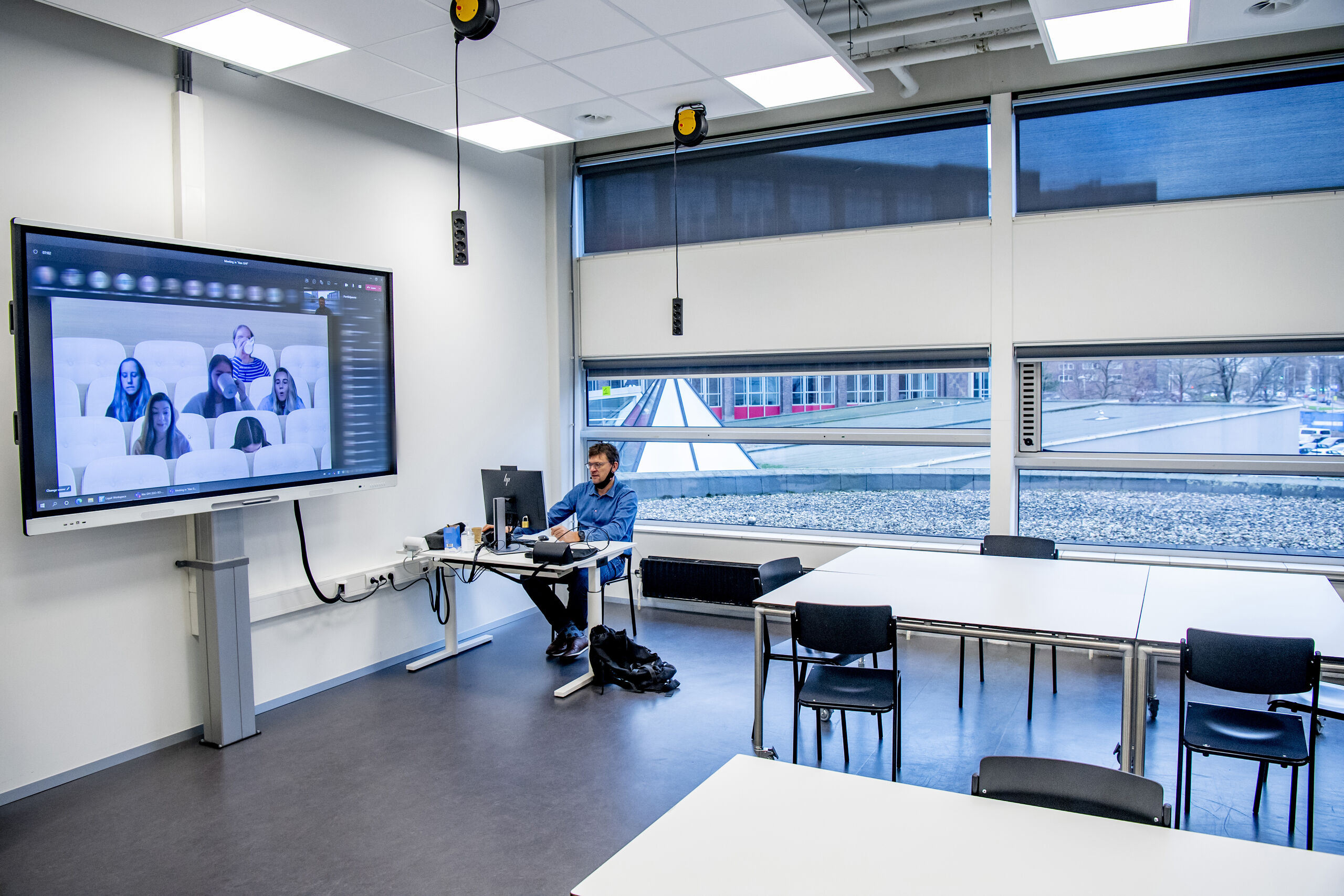 Een leraar van de Hogeschool Rotterdam digitaal les aan zijn studenten 