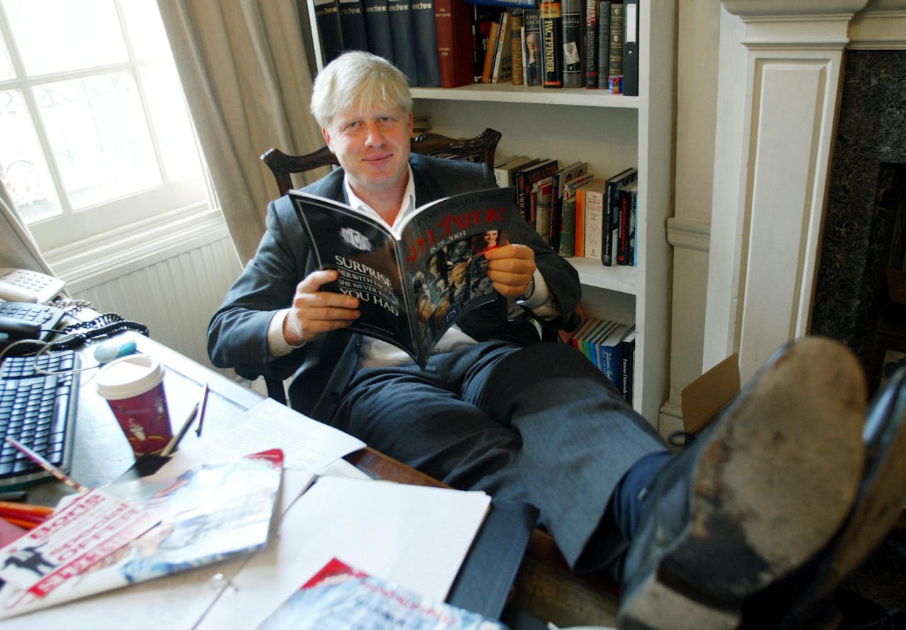(FILES) In this file photo taken on September 25, 2003 TO GO WITH STORY: LIFESTYLE-BRITAIN-MEDIA. The editor of The Spectator magazine, Boris Johnson, sits in his London office reading the anniversary issue of The Spectator marking 175 years of publication. AFP PHOTO/Jim WATSON - Since coming to power in July, Boris Johnson has shed his image as a jovial, wisecracking mophead to reveal a ruthless streak that has marked him out since childhood. (Photo by Jim WATSON / AFP)