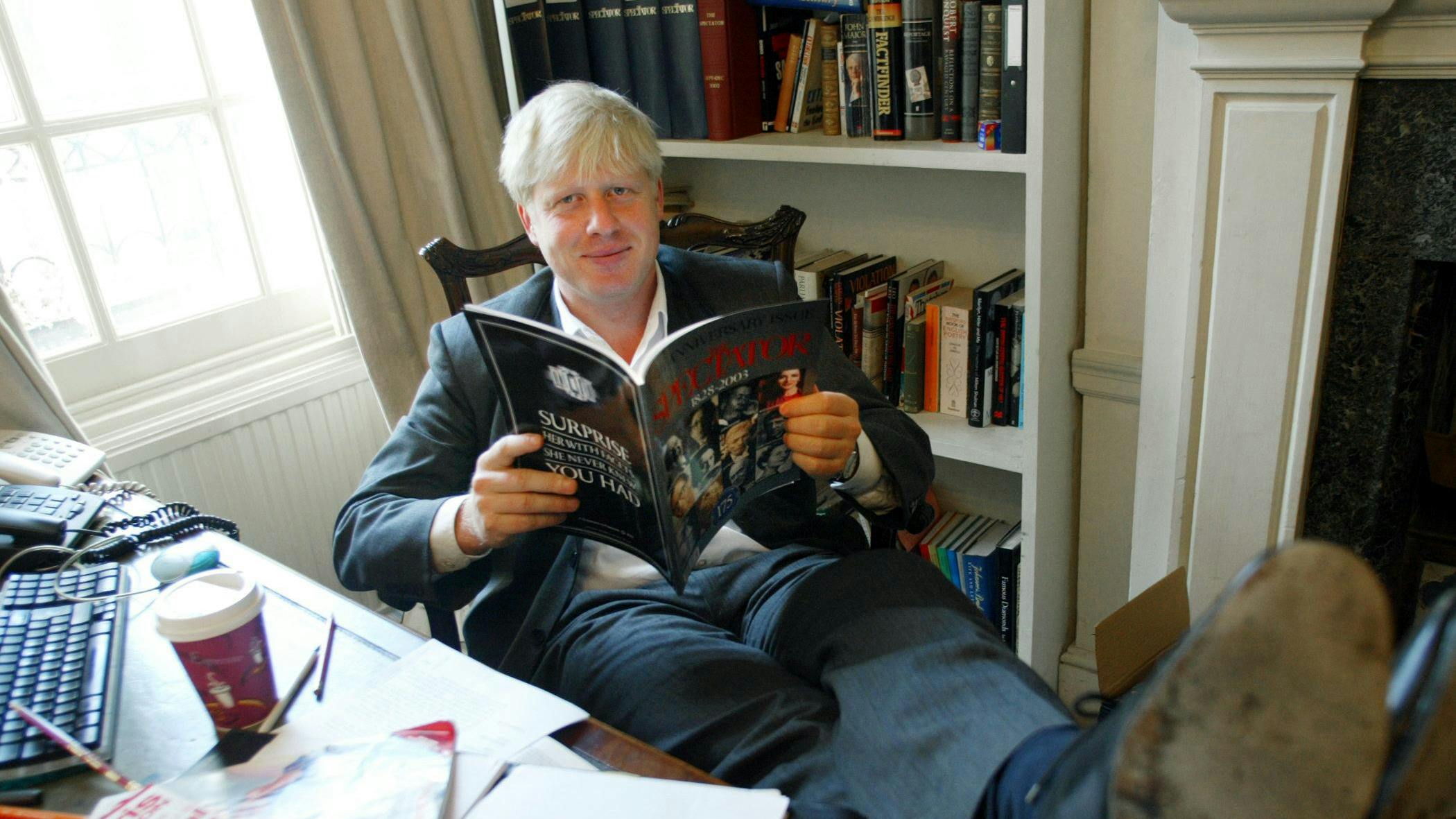 (FILES) In this file photo taken on September 25, 2003 TO GO WITH STORY: LIFESTYLE-BRITAIN-MEDIA. The editor of The Spectator magazine, Boris Johnson, sits in his London office reading the anniversary issue of The Spectator marking 175 years of publication.             AFP PHOTO/Jim WATSON - Since coming to power in July, Boris Johnson has shed his image as a jovial, wisecracking mophead to reveal a ruthless streak that has marked him out since childhood. (Photo by Jim WATSON / AFP)