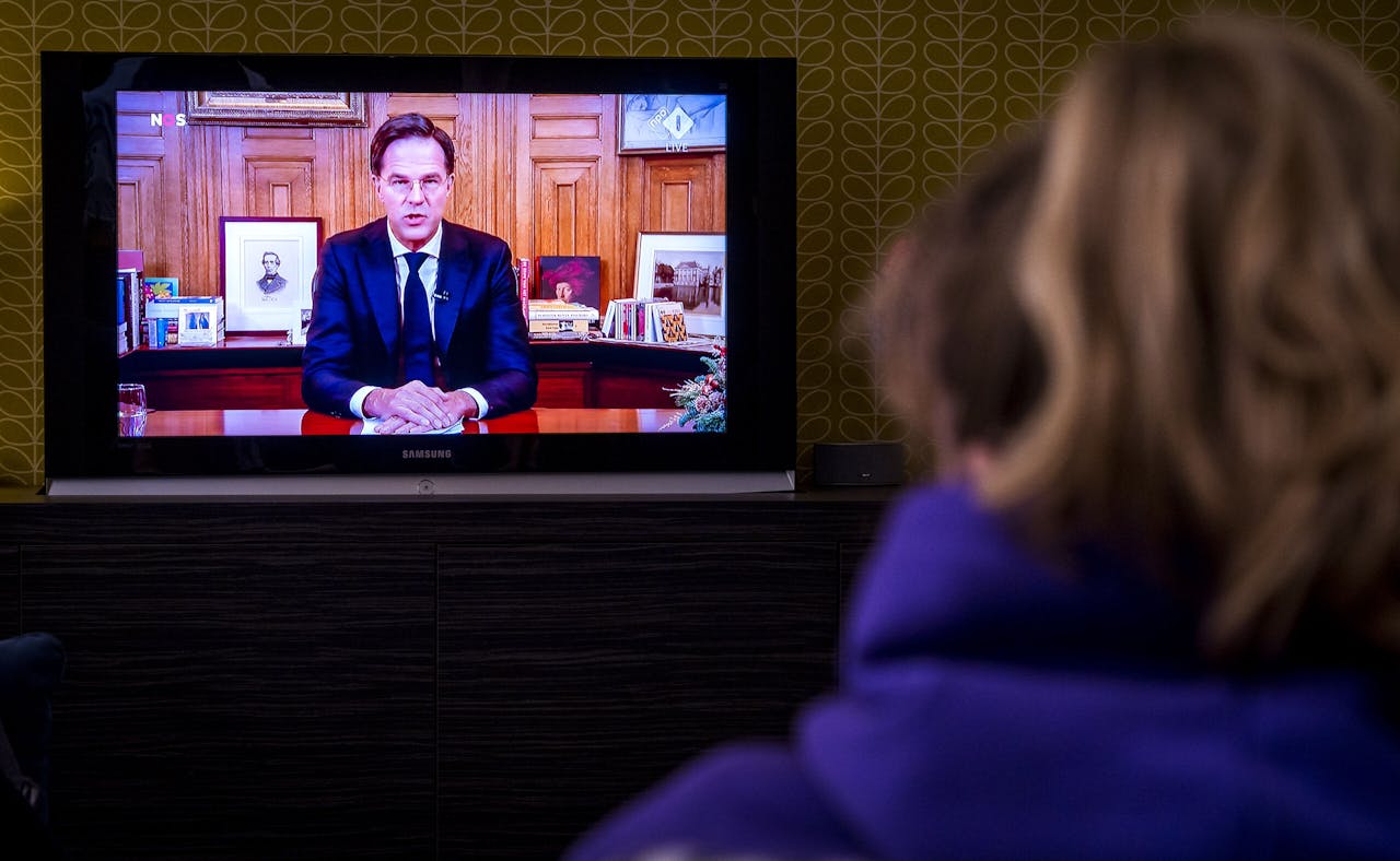 Een gezin met schoolgaande kinderen kijkt naar de toespraak van premier Mark Rutte over verscherping van de coronaregels die op televisie werd uitgezonden. Het was de tweede keer dit jaar dat de minister-president een toespraak over de coronacrisis hield vanuit het Torentje.