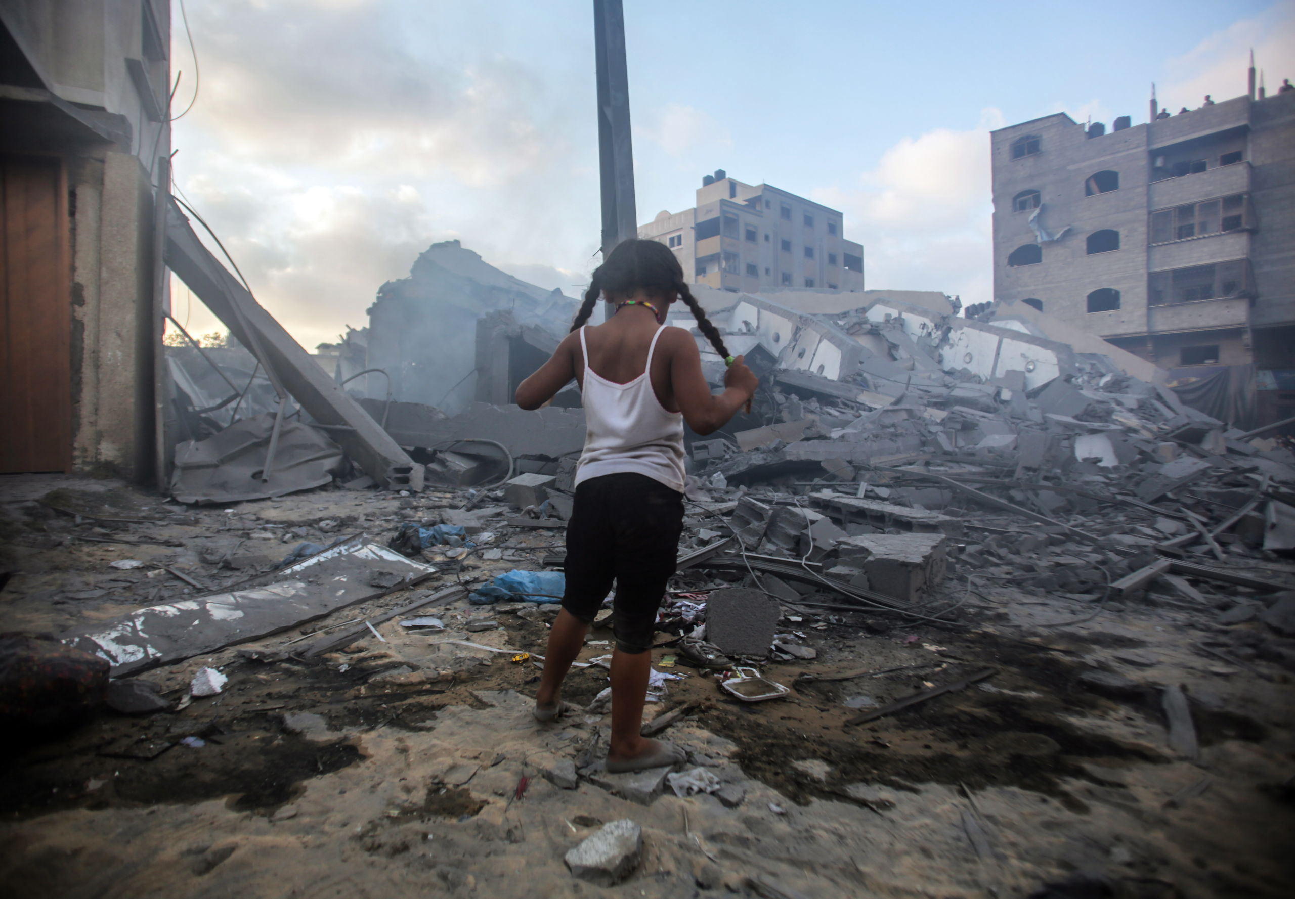 Een kind kijkt naar de ravage die is aangericht door een Israelisch luchtbombardement